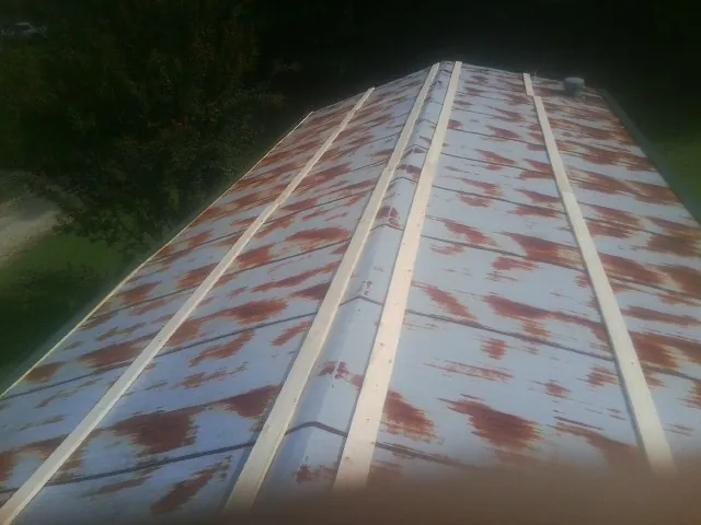 Rusted metal roof panels with new wood purlins before replacement — Storm Damage Roof Repair in Willseyville by Roofing Brothers