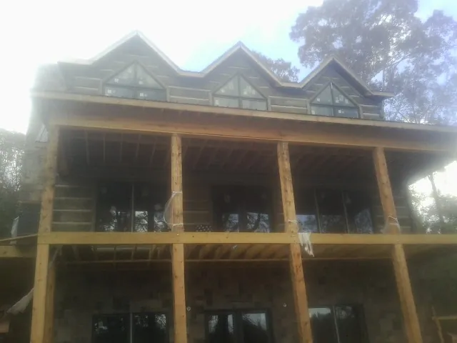 Dormers and porch framing on a large log home under construction — Roof Coating work by our crew in Willseyville